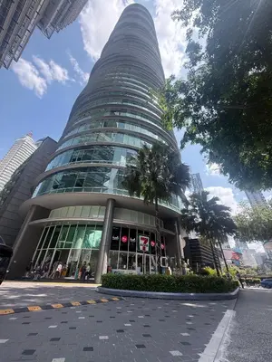 a tall glass building with a palm tree in front of it at Vortex Suites By Asian in Kuala Lumpur