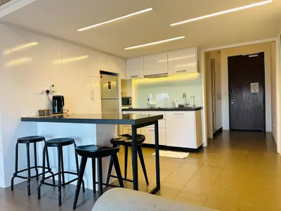 a kitchen with a counter and bar stools at The Establishment LOFT Bangsar KL Sentral by \u54c1\u5c4b PINWU Shortstay in Kuala Lumpur