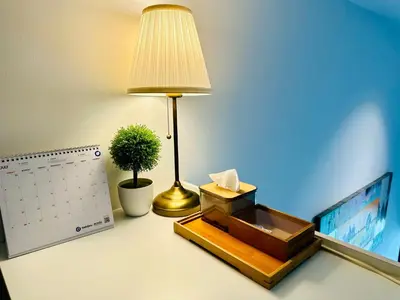 a desk with a lamp and a calendar and a plant at The Establishment LOFT Bangsar KL Sentral by \u54c1\u5c4b PINWU Shortstay in Kuala Lumpur