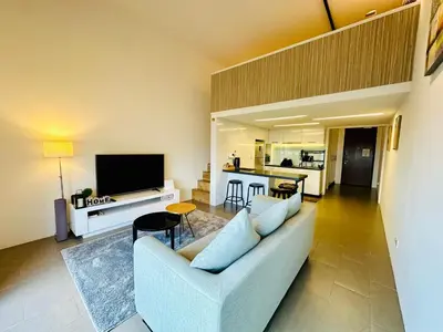 a living room with a couch and a tv at The Establishment LOFT Bangsar KL Sentral by \u54c1\u5c4b PINWU Shortstay in Kuala Lumpur