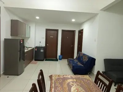 a living room with a table and a kitchen with a refrigerator at Serene Haven in Kuala Lumpur