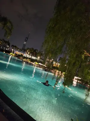 a man laying in a swimming pool at night at TRION KL Family Residence at Kuala Lumpur in Kuala Lumpur