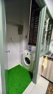 a laundry room with a washing machine and green carpet at AS Homes Kuala Lumpur in Kuala Lumpur