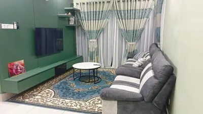 a living room with a couch and a tv at Twin Tower View Homestay Kuala Lumpur in Kuala Lumpur