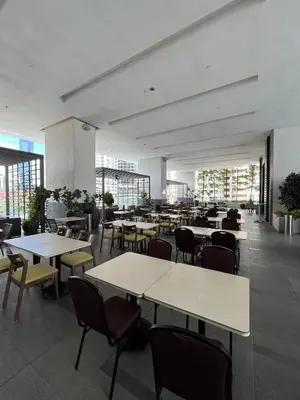 a dining room with tables and chairs and windows at Stylish Studio in ChangKat in Kuala Lumpur