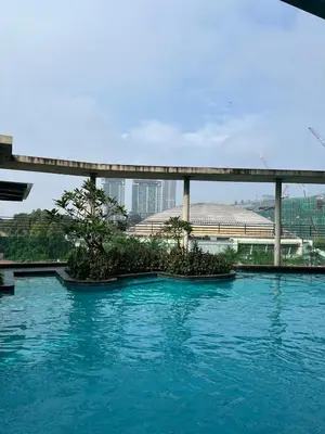 a pool of blue water with trees and a bridge at Casa Residency in Bukit in Kuala Lumpur