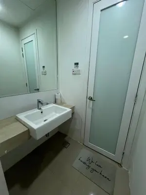 a bathroom with a sink and a shower with a mirror at Convenient KLCC 2-Bedroom Unit in Kuala Lumpur