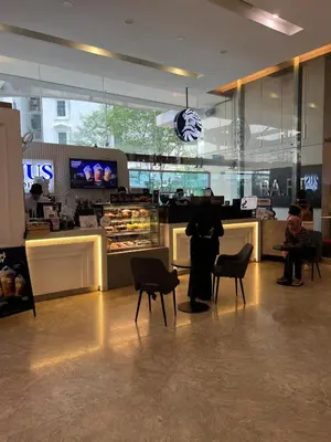 a person sitting at a table in a bakery at Convenient KLCC 2-Bedroom Unit in Kuala Lumpur