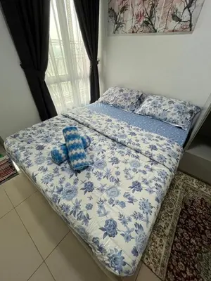 a bed with a blue and white comforter and two blue shoes at Ayuanura Homestay in Kuala Lumpur