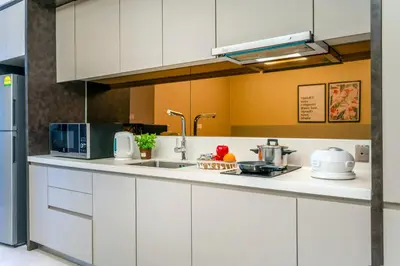 a kitchen with white cabinets and a sink at Dorsett Residences Sri Hartamas, Mont Kiara Kuala Lumpur in Kuala Lumpur