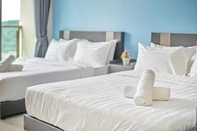 two beds with white sheets and towels on them at Dorsett Residences Sri Hartamas, Mont Kiara Kuala Lumpur in Kuala Lumpur
