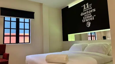 a bedroom with a white bed and a mirror at Star Mews Hotel Changkat Bukit Bintang in Kuala Lumpur