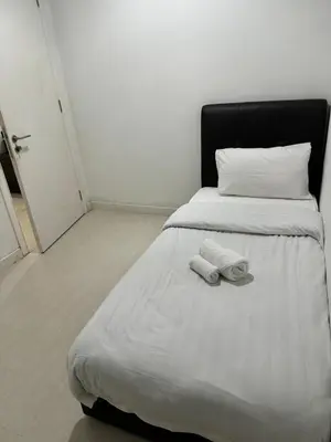 a bedroom with a bed with two towels on it at Convenient KLCC in Kuala Lumpur