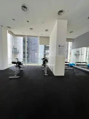 a gym with two exercise bikes in a room with windows at Convenient KLCCAmpang Park Unit in Kuala Lumpur