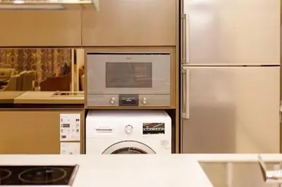 a kitchen with a washing machine and a refrigerator at Dorsett Residence TRX KLCC #25 in Kuala Lumpur