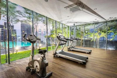 a gym with several tread machines in a room with windows at Dorsett Residence TRX KLCC #25 in Kuala Lumpur