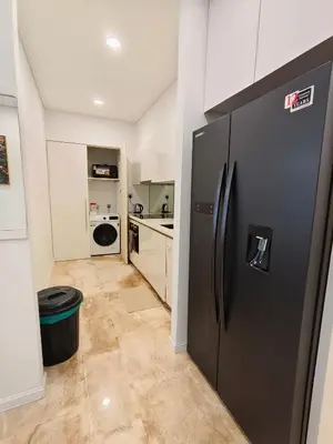 a kitchen with a black refrigerator in a room at Sky Suites KLCC Apartment by Family Room Stay in Kuala Lumpur