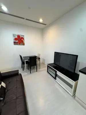a living room with a flat screen tv and a table at Cosy 2-bedroom KLCC in Kuala Lumpur