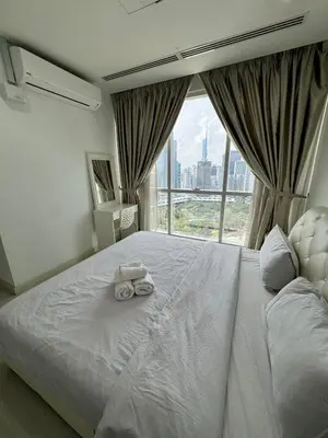 a bedroom with a large white bed with a window at Cosy 2-bedroom KLCC in Kuala Lumpur