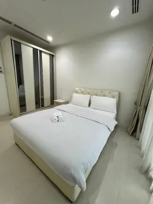 a bedroom with a large white bed with towels on it at Great Value 2-Bedroom KLCC Unit in Kuala Lumpur