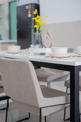a dining room table with chairs and a table with yellow flowers at RC Residence By Feel Home in Kuala Lumpur
