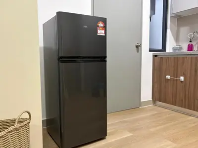a black refrigerator in a kitchen next to a door at Perfect for Families & Larger Groups, KL MRT- M Vertica in Kuala Lumpur