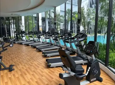 a gym with a row of treadmills and ellipticals at trion kl one bedroom studio in Kuala Lumpur