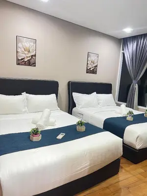 two beds in a hotel room with flowers at Vortex Suites KLCC, 10 Pax - 3 Bedrooms Apartment in Kuala Lumpur