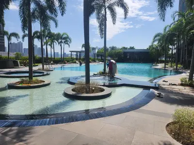 a swimming pool with palm trees in a resort at TRION Grand Service Suites at KL in Kuala Lumpur