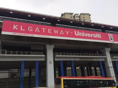 a bus is parked in front of a building at KL Gateway Residence Bangsar by The Luxe in Kuala Lumpur