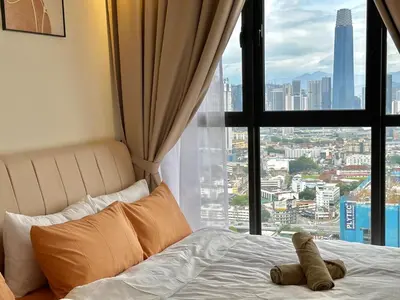 a teddy bear laying on a bed in front of a window at 9 Pax 3R3B Trion KL City View 10Mins to KLCC in Kuala Lumpur