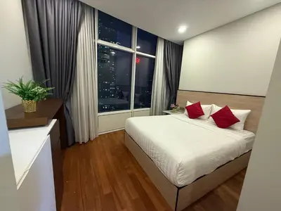a bedroom with a bed with red pillows and a window at Sky Premium suites klcc in Kuala Lumpur