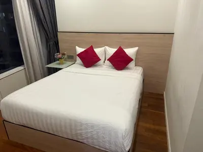 a bedroom with a bed with two red pillows at Sky Premium suites klcc in Kuala Lumpur