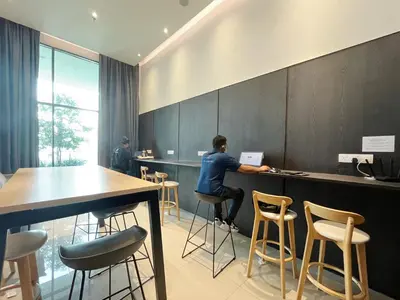 a person sitting at a bar in a room with stools at The colony by Klcc view sweet home in Kuala Lumpur