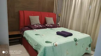 a bed with a red headboard and two pillows on it at Cozy Kenwingston Platz KL 2-5 Pax 2BR & 2BR FrePakin Netflix 2802 in Kuala Lumpur