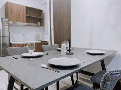 a table with plates and wine glasses on it at Cozy Kenwingston Platz KL 2-5 Pax 2BR & 2BR FrePakin Netflix 2802 in Kuala Lumpur