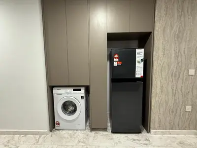 a kitchen with a washing machine and a refrigerator at Eaton Premier Suite KLCC in Kuala Lumpur
