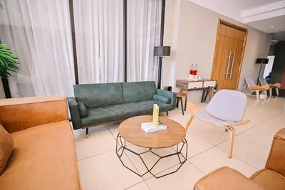 a living room with a green couch and a table at Kingston Hotel 12 - Jalan Raja Laut, KL in Kuala Lumpur