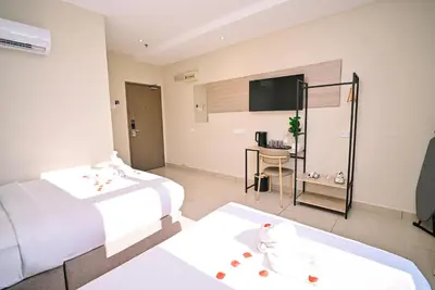 a hotel room with two beds and a flat screen tv at Kingston Hotel 12 - Jalan Raja Laut, KL in Kuala Lumpur