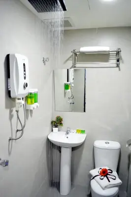 a white bathroom with a sink and a toilet at EASSY Hotel KL Sentral in Kuala Lumpur