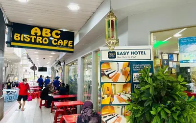 a store with people sitting at tables in a shopping mall at EASSY Hotel KL Sentral in Kuala Lumpur
