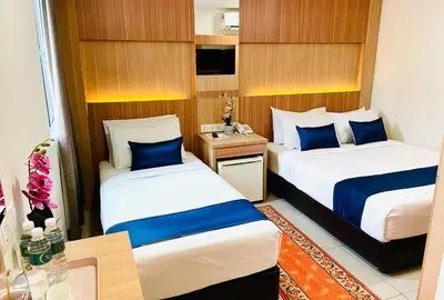a hotel room with two beds with blue and white sheets at EASSY Hotel KL Sentral in Kuala Lumpur