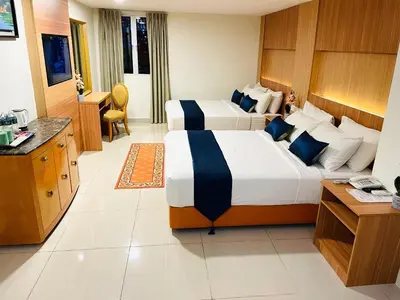 a hotel room with two beds and a desk at EASSY Hotel KL Sentral in Kuala Lumpur
