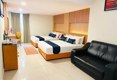 a hotel room with two beds and a couch at EASSY Hotel KL Sentral in Kuala Lumpur
