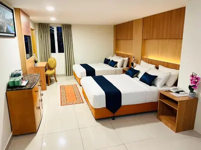 a hotel room with two beds and a television at EASSY Hotel KL Sentral in Kuala Lumpur