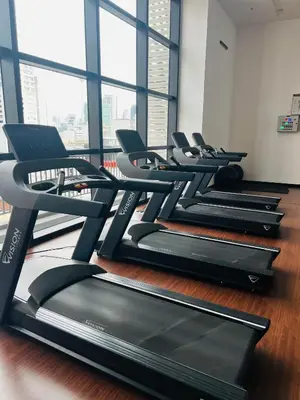 a row of treadmills in a gym with windows at Chamber KL Residence by Moon Orchid in Kuala Lumpur