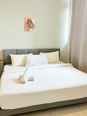 a bed with two white socks on top of it at Chamber KL Residence by Moon Orchid in Kuala Lumpur