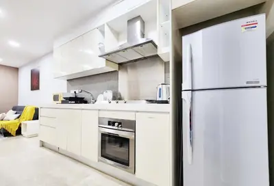 a kitchen with white cabinets and a refrigerator at Bukit Bintang Fairlane Residence Kuala Lumpur #1510 in Kuala Lumpur