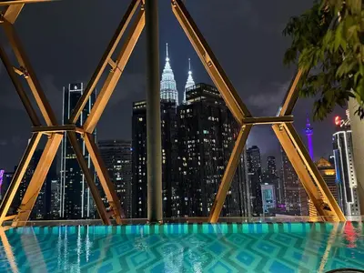 a pool with a view of the city at night at Scarletz Suites KLCC by TaheeenS in Kuala Lumpur