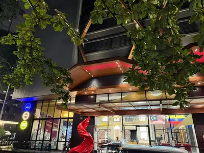 a building with a red sculpture in front of it at Scarletz Suites KLCC by TaheeenS in Kuala Lumpur